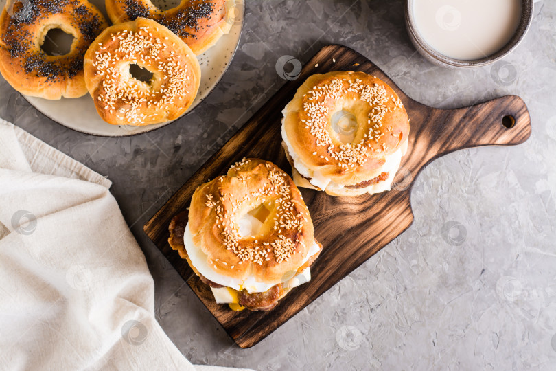 Скачать Рогалики с жареным мясом, яйцом пашот и сыром на доске на столе. Домашний фаст-фуд. Вид сверху фотосток Ozero