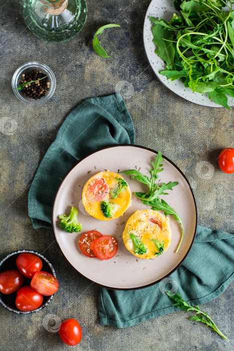 Скачать Порционный омлет из яиц, брокколи и помидоров на тарелке. Домашний завтрак. Верхний и вертикальный фотосток Ozero