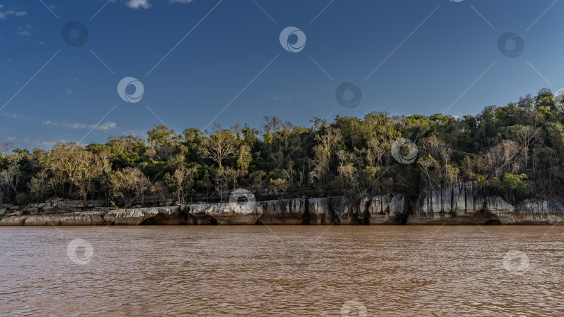 Скачать Спокойная река с красно-коричневой водой и скалистыми известняковыми берегами. фотосток Ozero