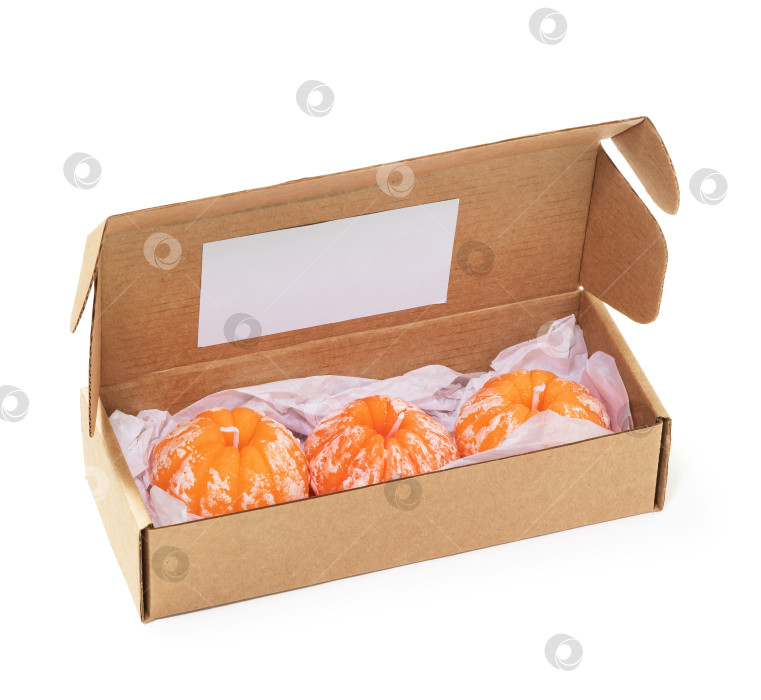 Скачать Открытая картонная коробка с тремя ароматическими свечами в форме мандаринов, выделенными на белом фоне фотосток Ozero