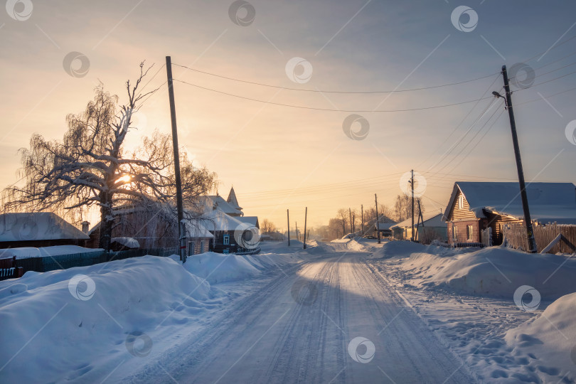 Скачать Зимняя дорога через заснеженную деревню, сильный мороз, снежная мгла. фотосток Ozero