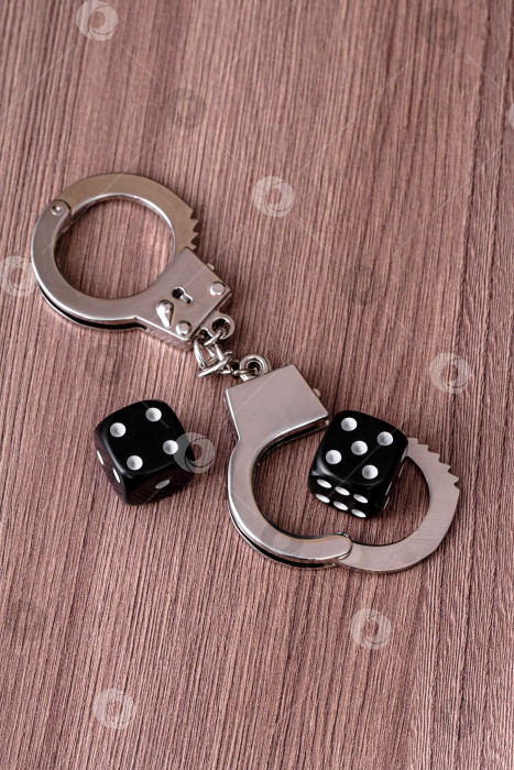 Скачать Полицейские наручники и два кубика на столе фотосток Ozero