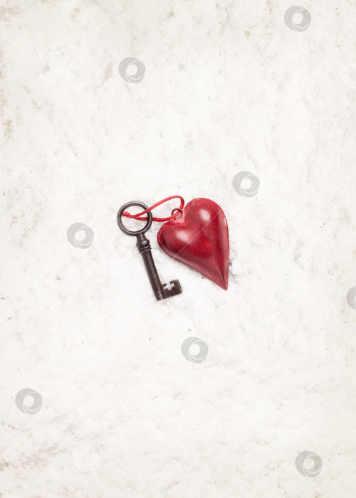 Скачать Украшение в виде сердца и старый ключ на фоне снега фотосток Ozero