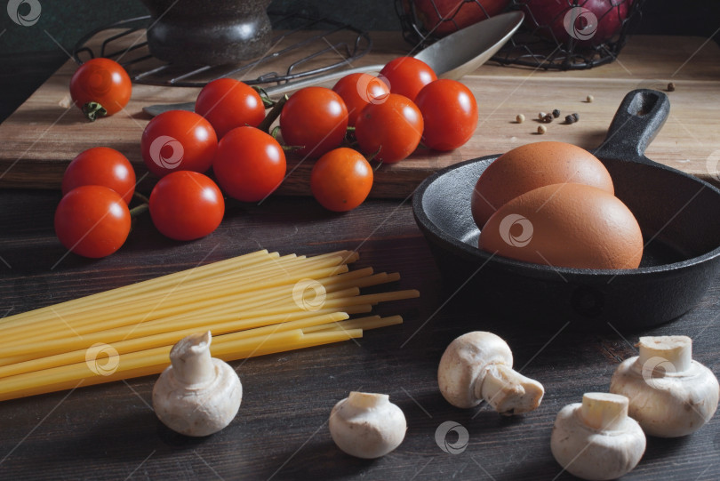 Скачать Кухонный стол со спагетти, помидорами, грибами и яйцами фотосток Ozero