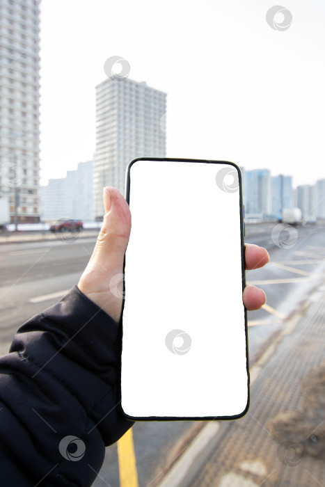 Скачать Телефон с белым экраном в руке на фоне города фотосток Ozero