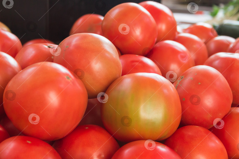 Скачать Аппетитные созревшие красно-бурые помидоры горкой лежат на рыночном прилавке фотосток Ozero
