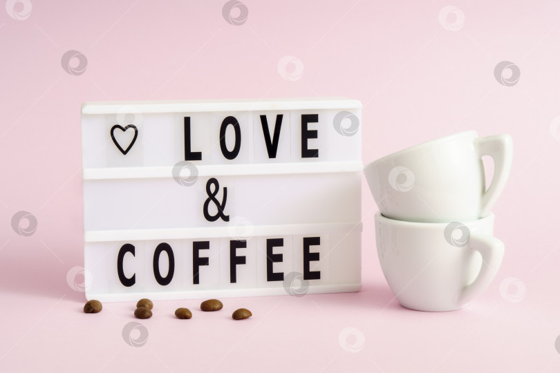 Скачать Любовь и кофе написаны буквами на лайтбоксе с кофейными зернами и парой чашек фотосток Ozero