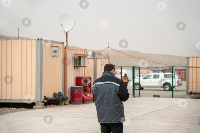 Скачать Вид сзади на мужчину, проходящего мимо жилых контейнеров фотосток Ozero