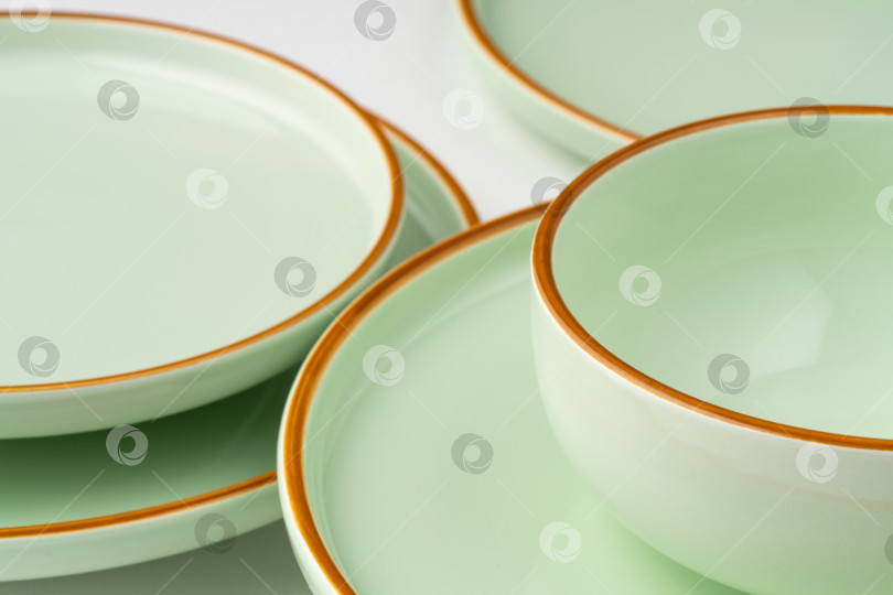 Скачать Набор керамической посуды пастельно-зеленого цвета с оранжевыми контурами фотосток Ozero