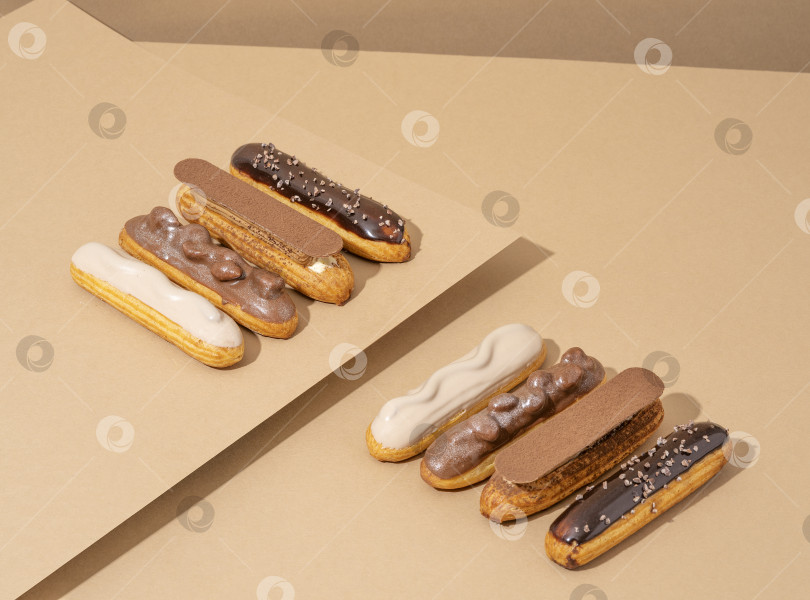 Скачать Набор восхитительных пончиков с глазурью различных вкусов, разложенных на картонной бумаге в привлекательной витрине фотосток Ozero