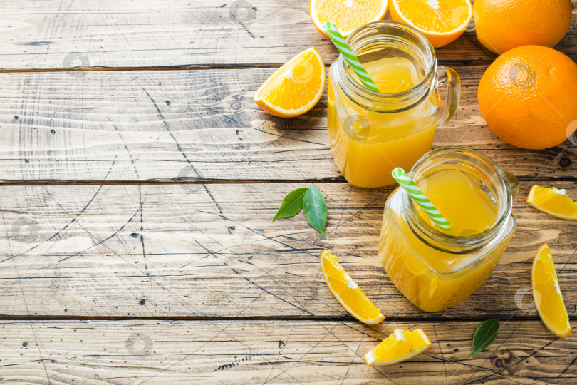 Скачать Апельсиновый сок в стеклянных банках и свежие апельсины на деревянном фоне в деревенском стиле. Скопируйте пробел. фотосток Ozero