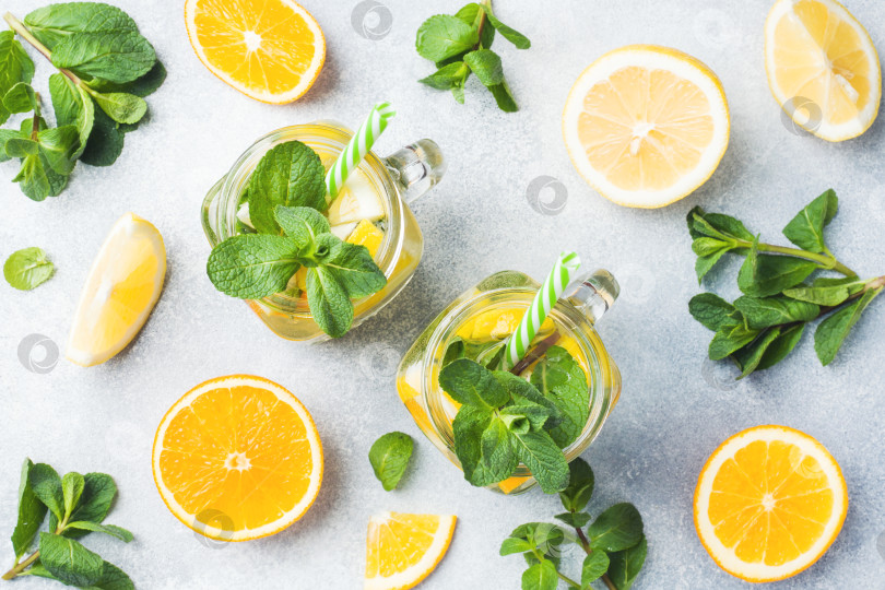 Скачать Лимонадный напиток из газированной воды, лимона и листьев мяты в банке на светлом фоне. фотосток Ozero