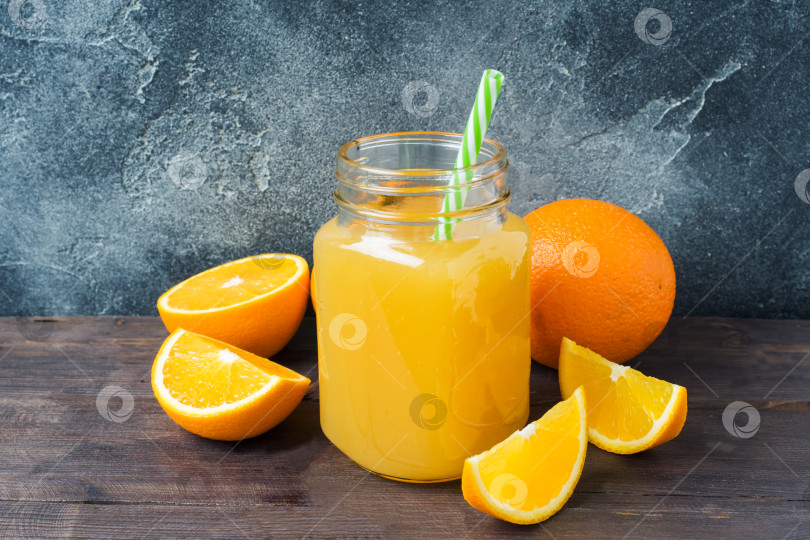 Скачать Апельсиновый сок в стеклянной банке и свежие фрукты апельсины на темном фоне с пробелом для копирования. фотосток Ozero