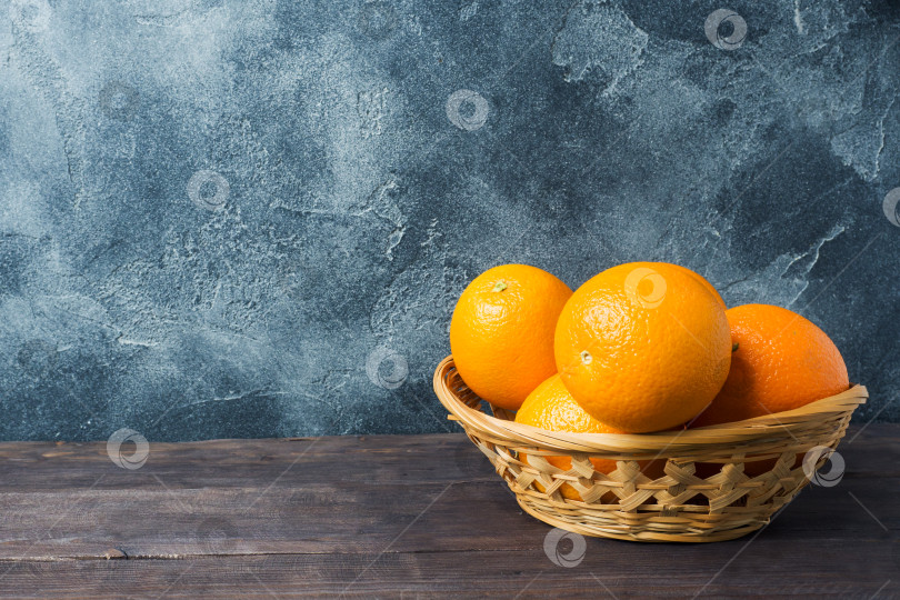 Скачать Свежие фрукты - апельсины в корзине на темном фоне. фотосток Ozero