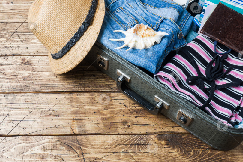 Скачать Концепция подготовки к путешествию с чемоданом, одеждой и аксессуарами на старом деревянном столе. Место для копирования вида сверху фотосток Ozero