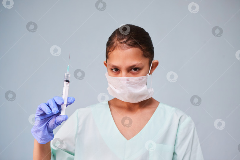 Скачать Девушка - молодая медсестра или ассистент в медицинской одежде и маске фотосток Ozero