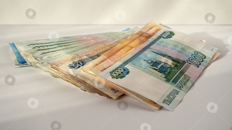 Скачать Российские банкноты аккуратно разложены веером на светлом фоне. Вид в перспективе. Зарплата, пенсия, выплаты. фотосток Ozero