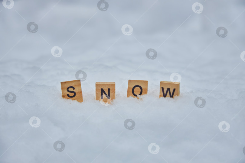 Скачать Надпись Snow на деревянных блоках, стоящих в снегу. Концепция зимнего сезона. фотосток Ozero