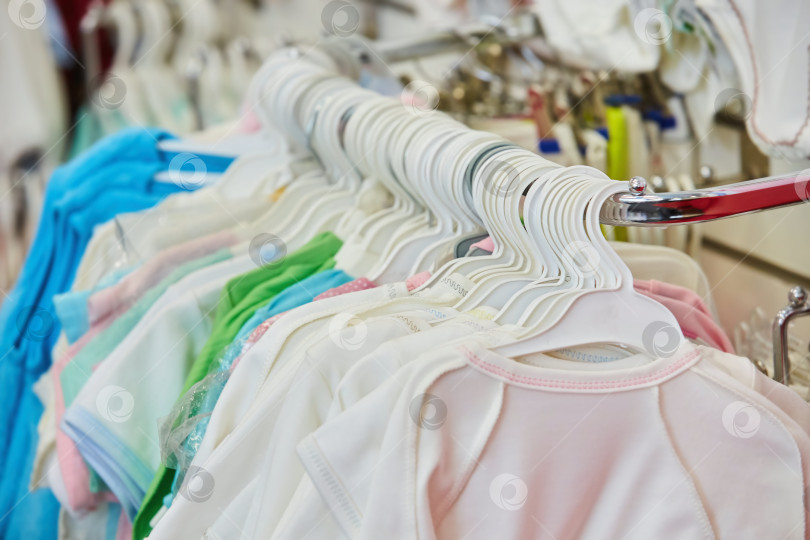 Скачать Товары предметы одежды висят на витрине в магазине. Производство и продажа детской одежды. фотосток Ozero