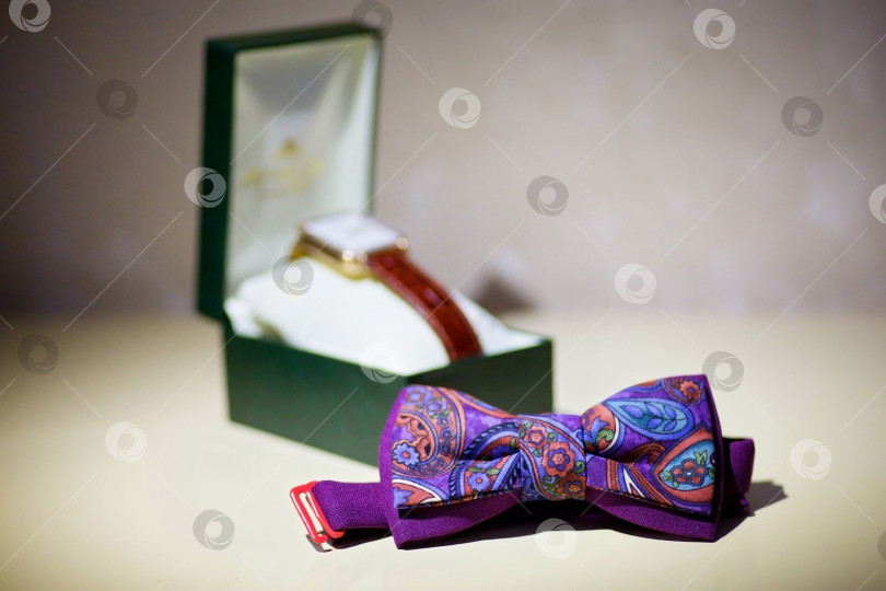 Скачать Мужской галстук-бабочка сиреневого цвета лежит на столе фотосток Ozero