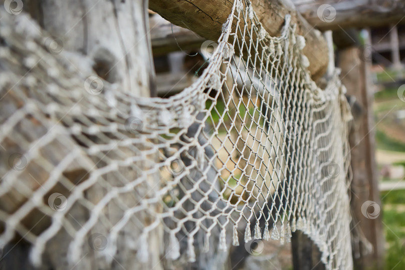 Скачать Старая рыболовная сеть, расстеленная на деревянных столбах здания. фотосток Ozero
