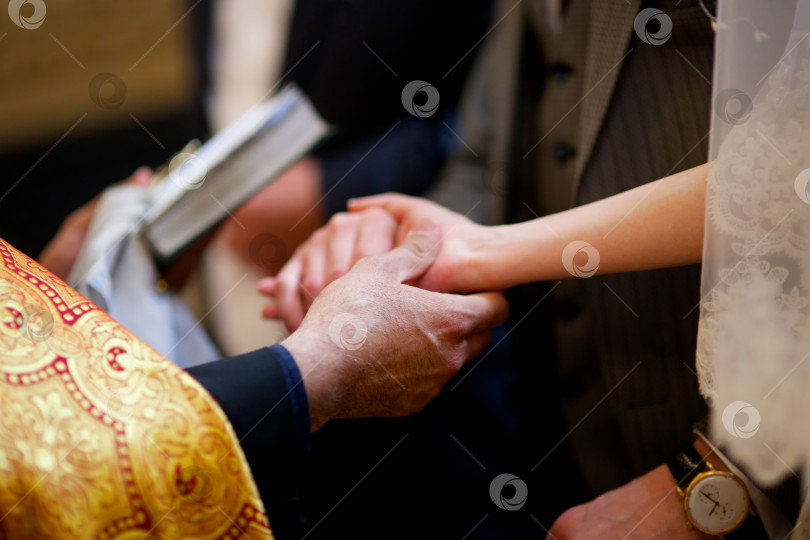 Скачать Руки молодоженов на венчании в церкви фотосток Ozero