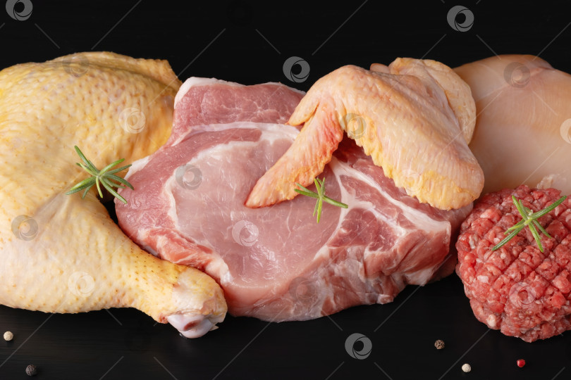 Скачать Различные виды сырого мяса - говядина, свинина, курица на черной деревянной доске фотосток Ozero