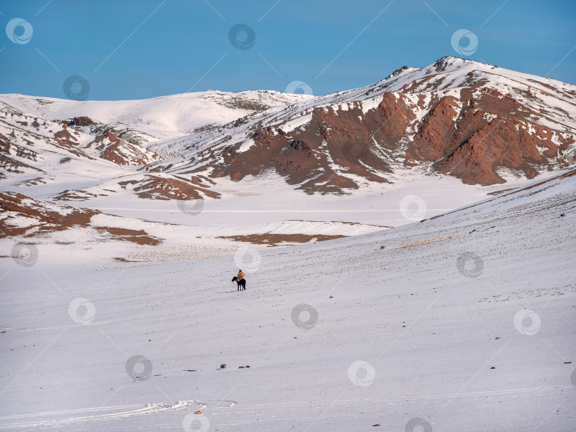 Скачать Всадник на белоснежном заснеженном горном склоне. фотосток Ozero