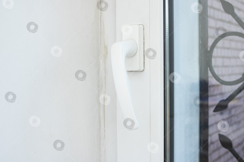 Скачать Белая оконная ручка на закрытом окне фотосток Ozero