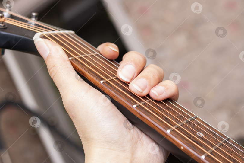 Скачать Пальцы на струнах черной гитары фотосток Ozero