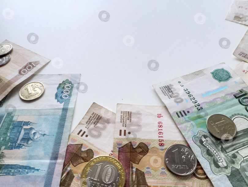 Скачать Российские купюры и монеты выложены полукругом на белом фоне. На фоне с деньгами есть место для текста. фотосток Ozero