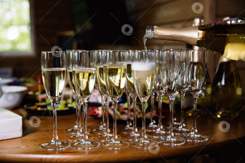 Скачать Разливаем шампанское по бокалам для празднования фотосток Ozero