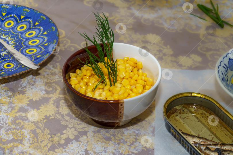 Скачать Консервированная кукуруза в тарелке и шпроты фотосток Ozero