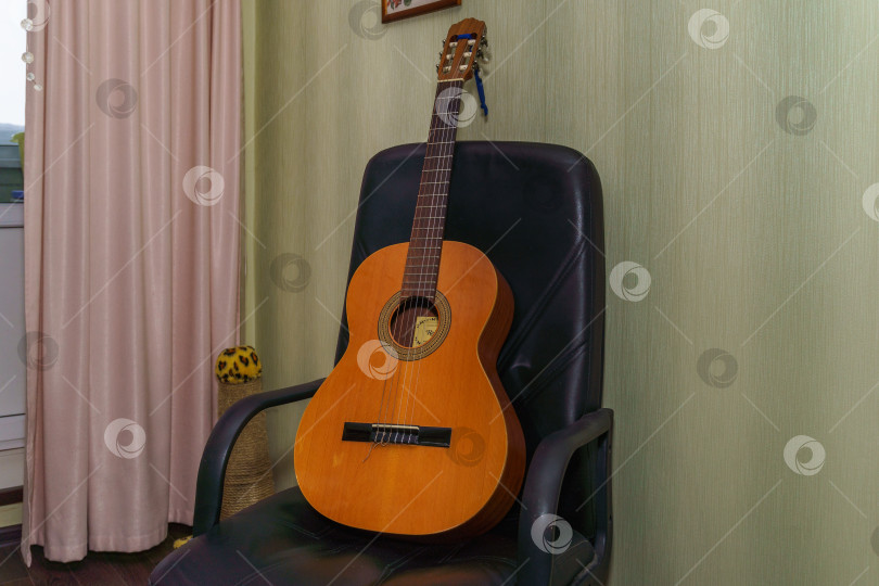 Скачать Акустическая гитара на кресле фотосток Ozero