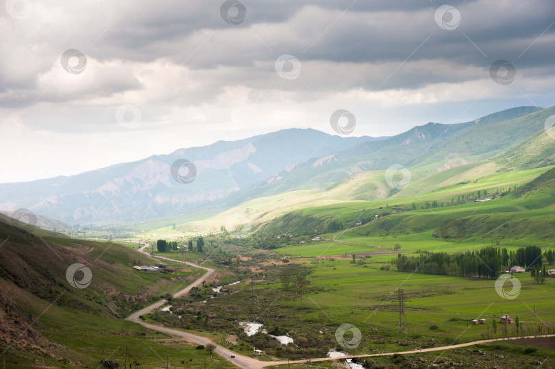 Скачать Горный пейзаж, дорога и деревня в горной долине Кыргызстана, Иссык-Ата фотосток Ozero