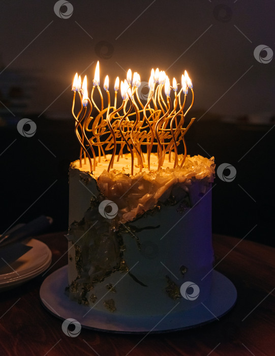 Скачать Элегантный праздничный торт с зажженными свечами в темной обстановке фотосток Ozero