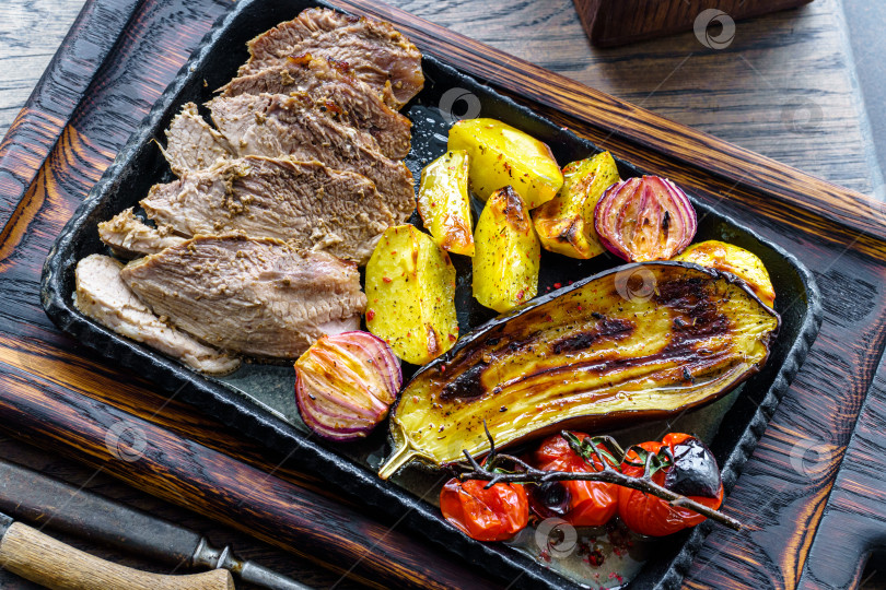 Скачать Овощи-гриль с мясом на чугунной решетке на верхнем столе фотосток Ozero