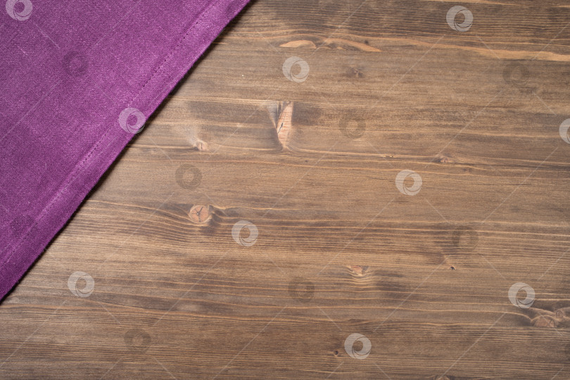 Скачать Фиолетовая салфетка с левого верхнего угла деревянного стола фотосток Ozero
