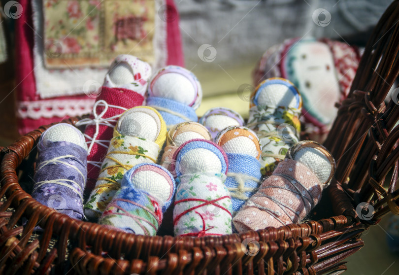 Скачать Национальные русские самодельные тряпичные куклы-новорожденные,лежащие в плетеной корзине фотосток Ozero