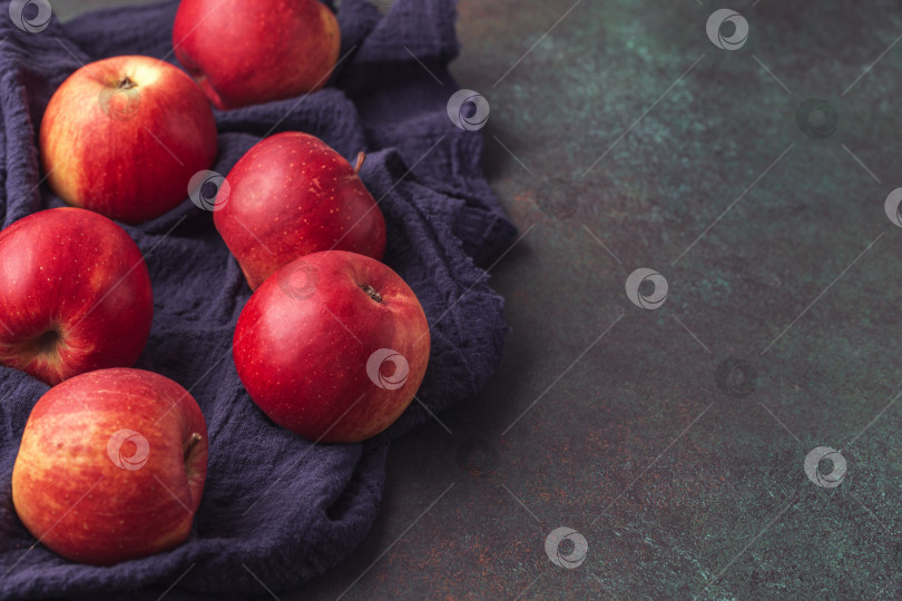 Скачать Спелые яблоки на синей салфетке на темном фотосток Ozero