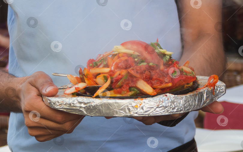 Скачать Руки официанта держат горячее блюдо фотосток Ozero