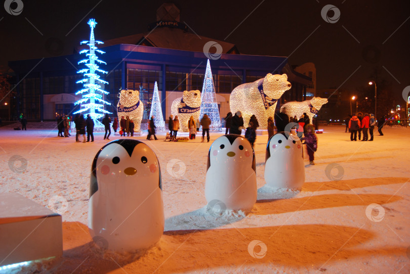 Скачать Тюмень, Россия, 09 января 2021: Фигуры пингвинов на фоне новогодней елки ночью возле цирка фотосток Ozero