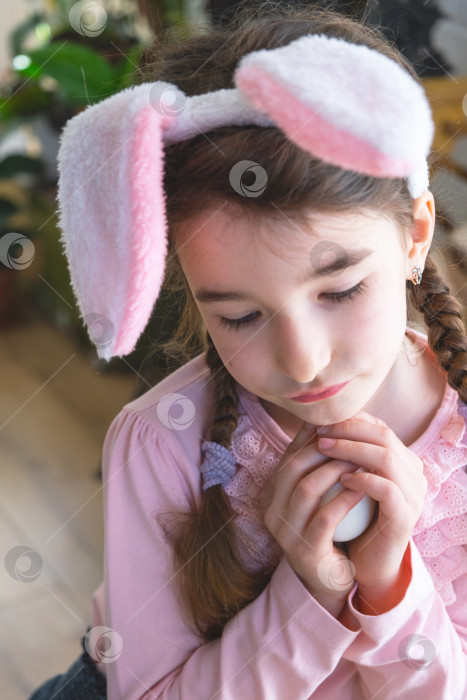 Скачать Милая девочка с розовыми заячьими ушками милый пасхальный портрет ребенка в интерьере фотосток Ozero