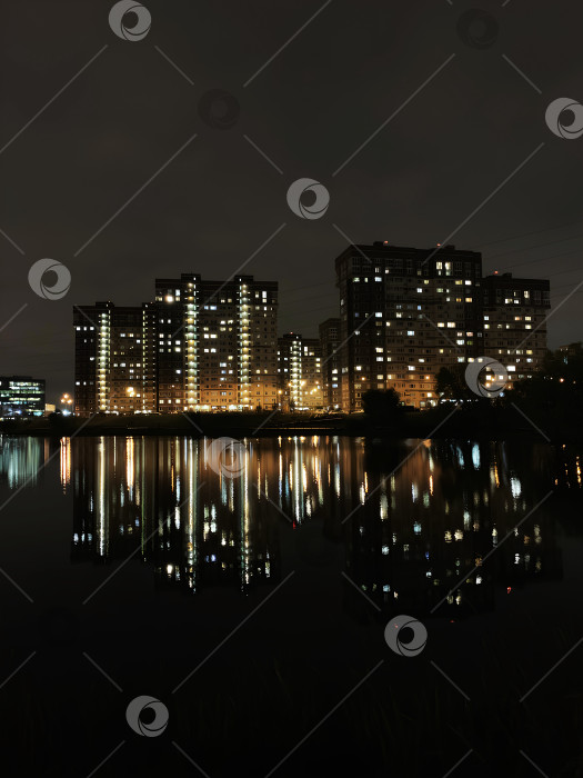 Скачать Ночной вид на современный город. Отражение домов в воде фотосток Ozero