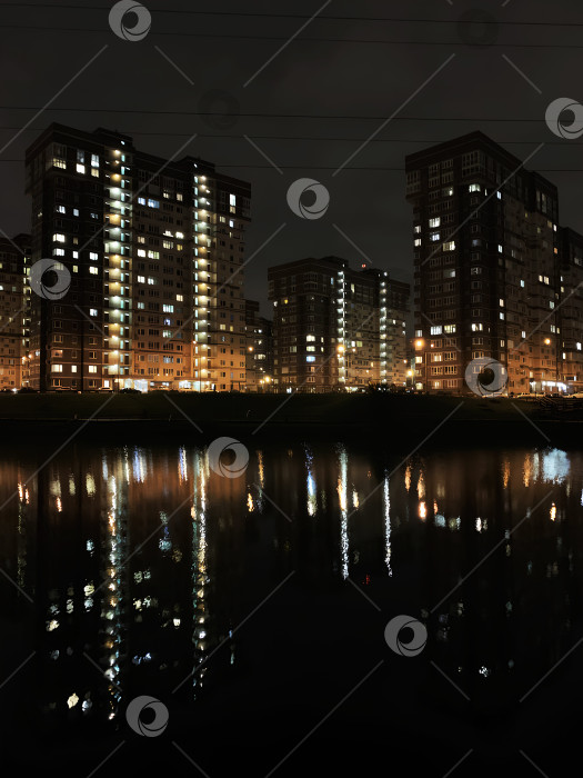 Скачать Ночной вид на современный город. Отражение домов в воде фотосток Ozero
