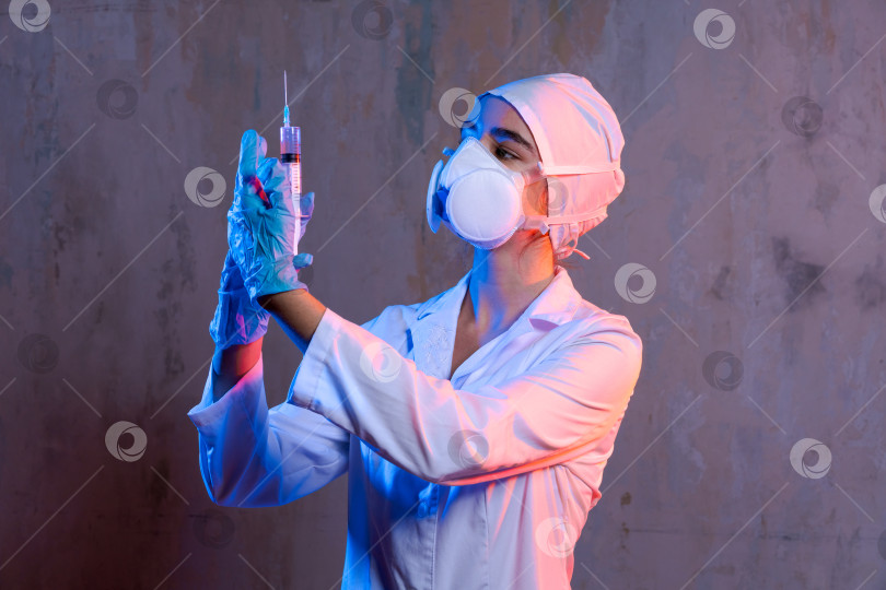 Скачать Женщина в белом лабораторном халате держит шприц фотосток Ozero