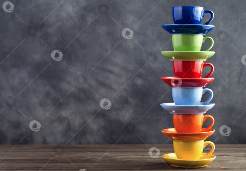 Скачать Стопка из шести разноцветных чашек на столе с правой стороны фотосток Ozero