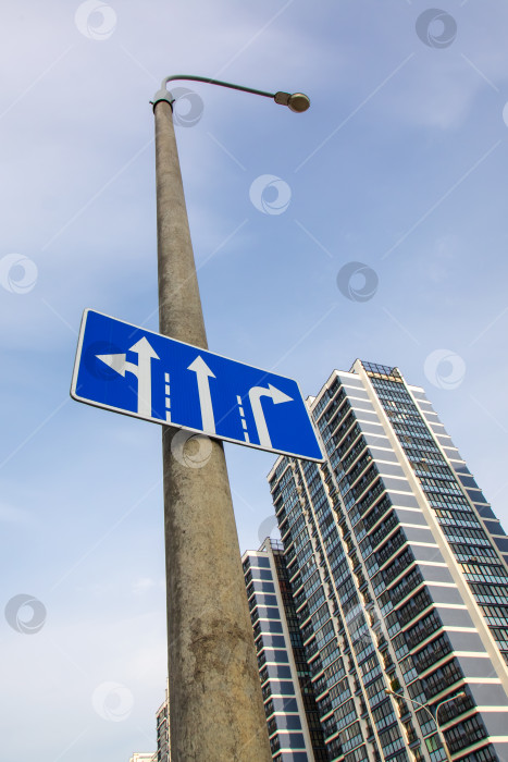 Скачать Дорожный знак со стрелками на фоне города фотосток Ozero