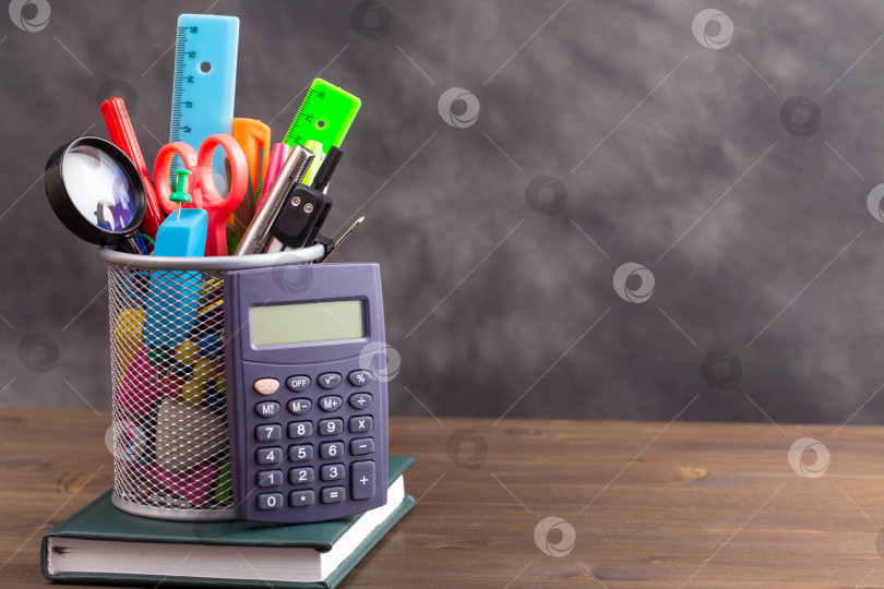 Скачать Канцелярские принадлежности с калькулятором слева на деревянном столе фотосток Ozero