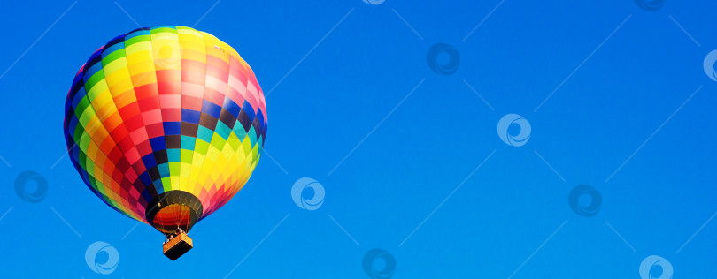 Скачать Разноцветный воздушный шар парит в утреннем голубом небе. Баннер. фотосток Ozero